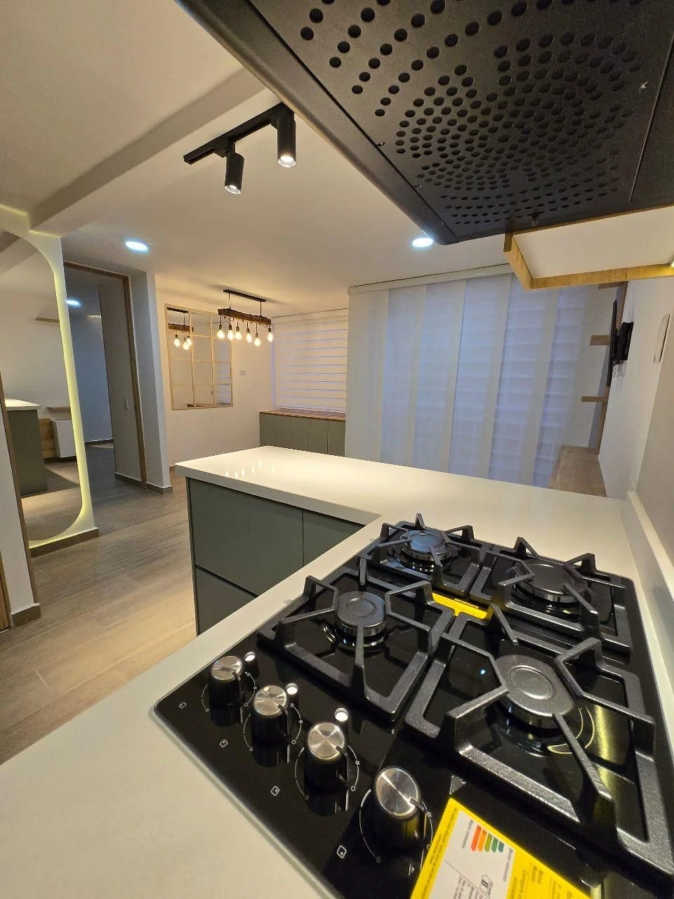 Cocina abierta con arco LED, barra y lámpara de madera