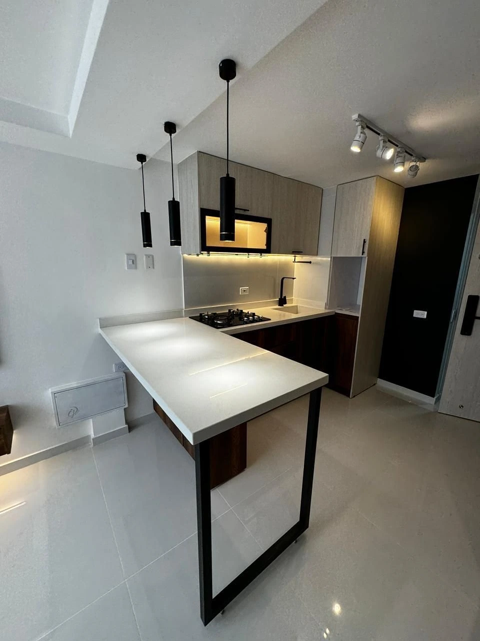 Cocina de dos tonos con barra, lámparas negras y LED