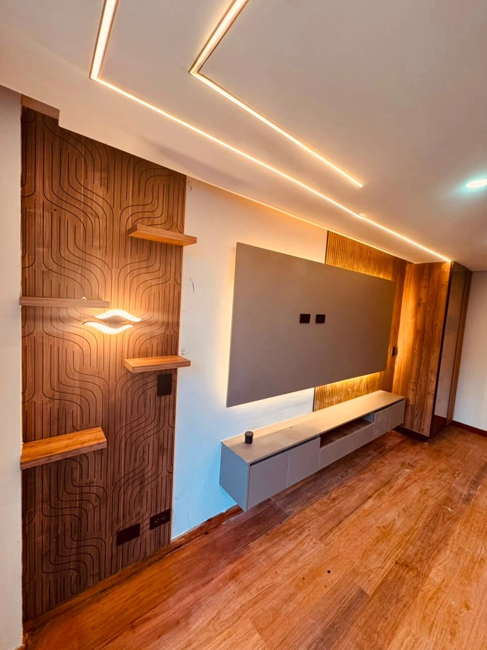 Panel de madera con ondas, estantes flotantes y mueble de TV a medida